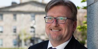 Brian Norton standing in front of a building